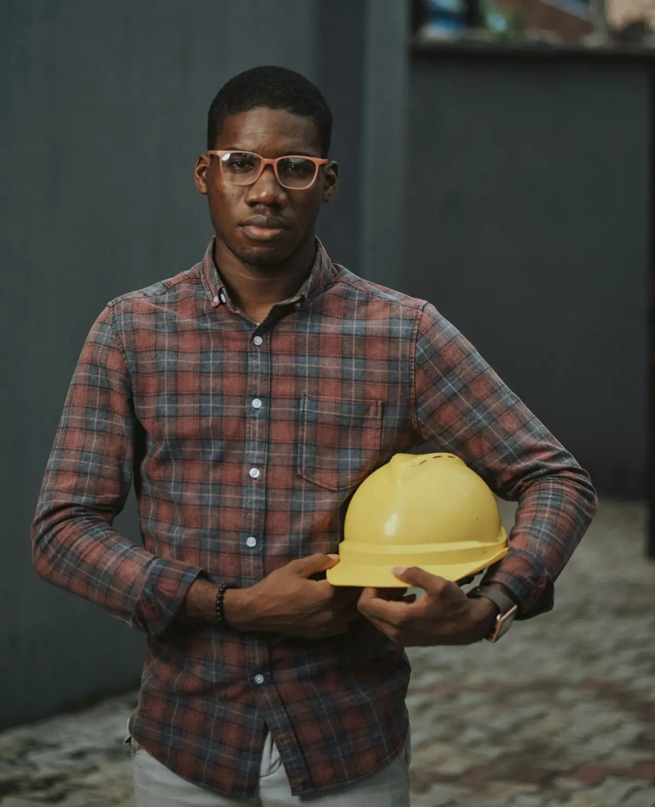 man in blue red and white plaid dress shirt holding yellow plastic bowl